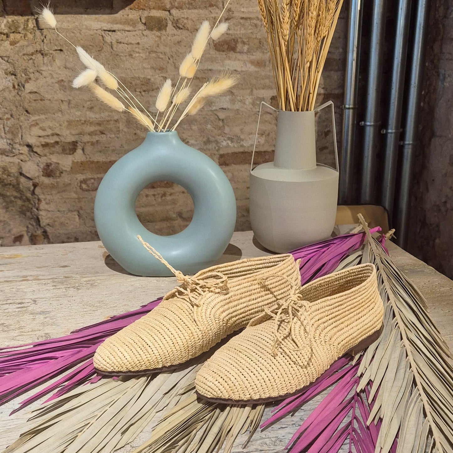 Zapato Aziza de Leke’s en rafia natural, sobre unas hojas de palmera seca