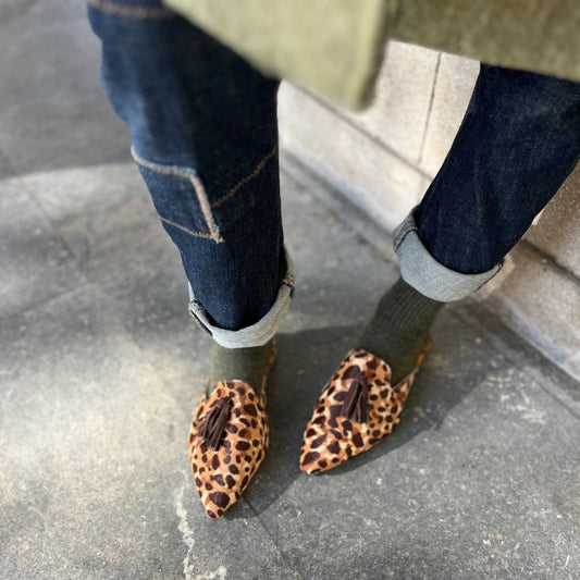 Look casual chic que combina con las mule Faiza. El look de jeans rectos de cintura alta en tono azul oscuro, calcetines de alpaca verdes y un abrigo oversize en verde aceituna.